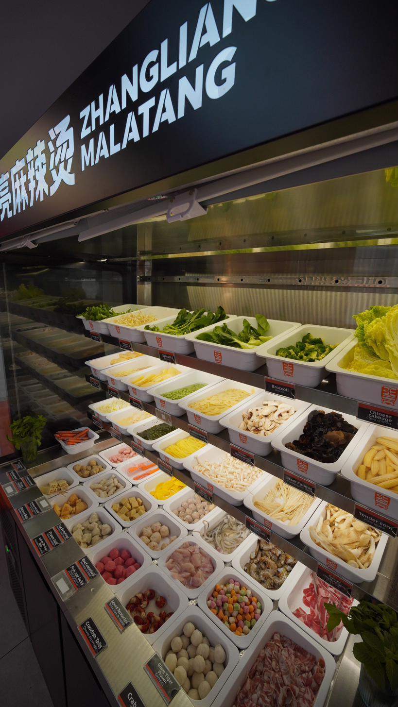 Les bacs étagés du comptoir : légumes verts, champignons, tofu, boulettes.