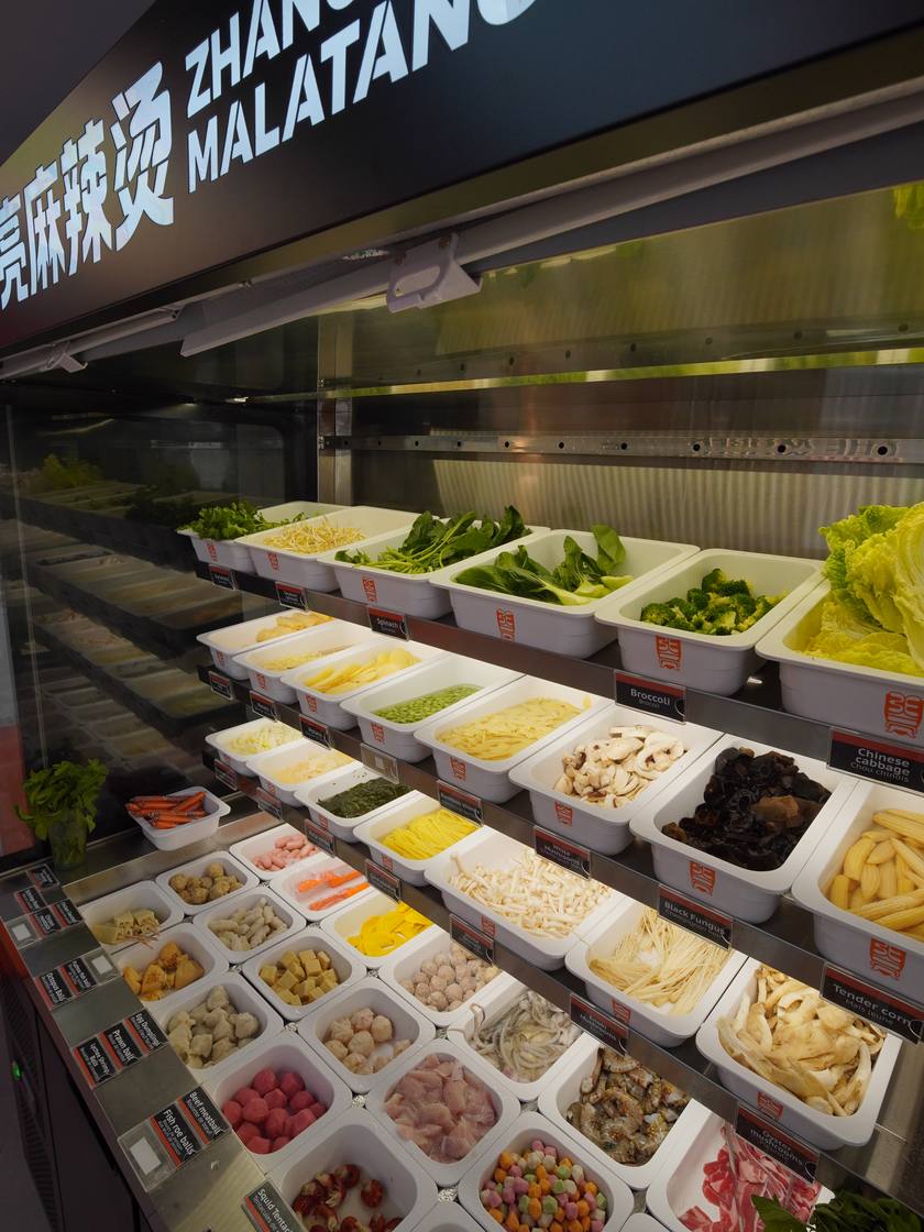 Les bacs du comptoir : légumes, tofu, nouilles et viandes fraîches.