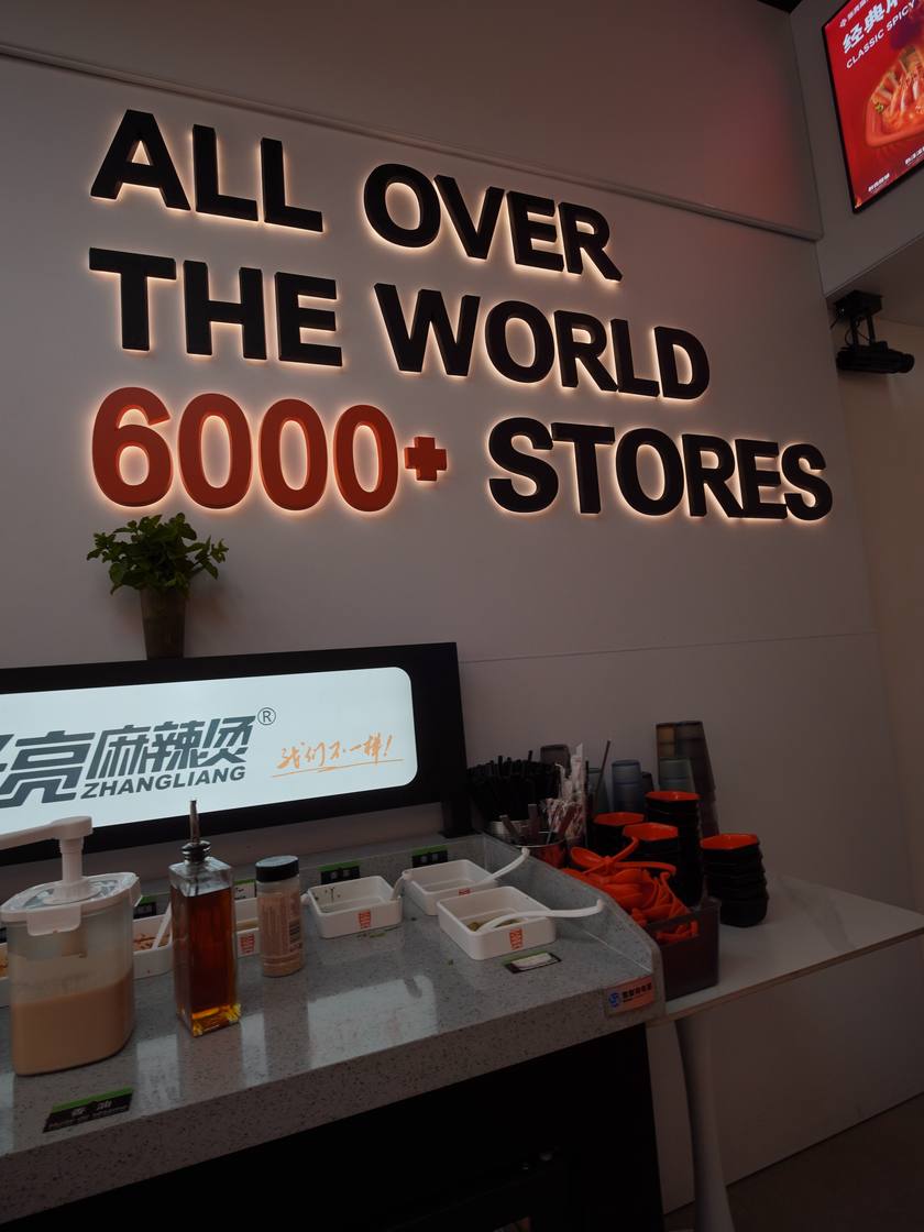 Le mur « All over the world, 6000+ stores » et la station des sauces.